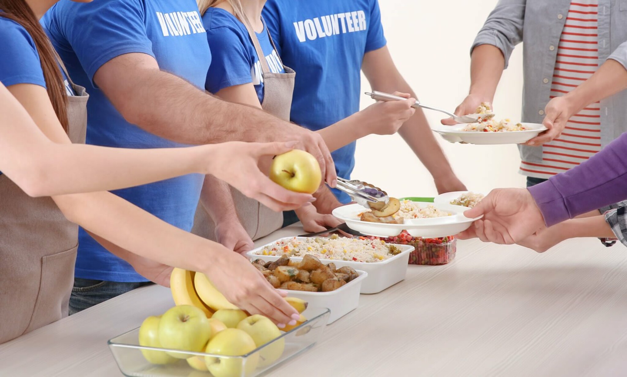 young-volunteers-serving-food-to-homeless-people.jpg